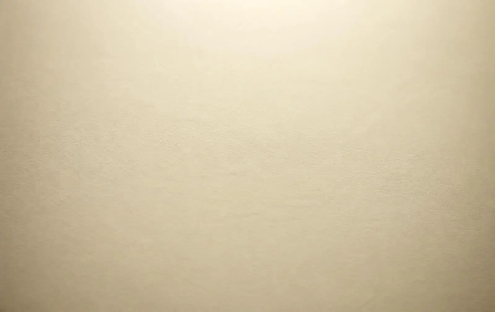 A clean unmarked sheet of cream paper, top lit